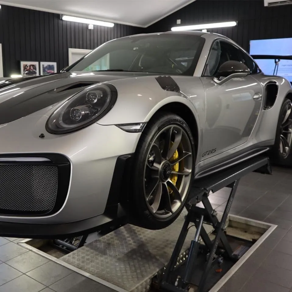 Sølvgrå Porsche 911 GT2 RS på løftebordet i studioet til RV Bilpleie